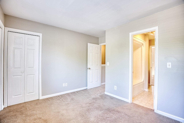 unfurnished bedroom with a closet and light colored carpet