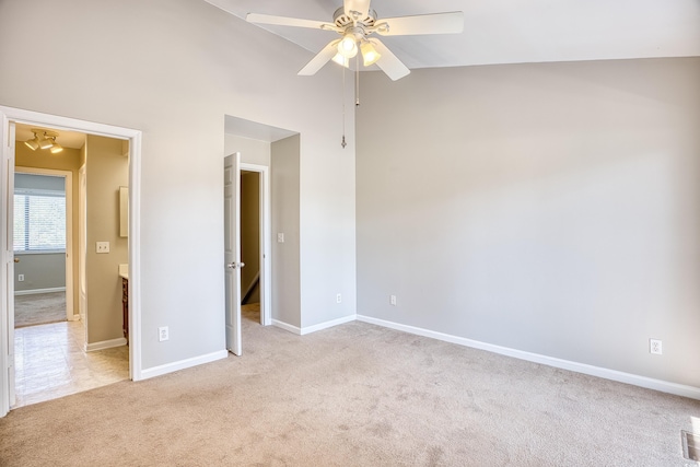 unfurnished bedroom with light carpet, ensuite bathroom, vaulted ceiling, and ceiling fan