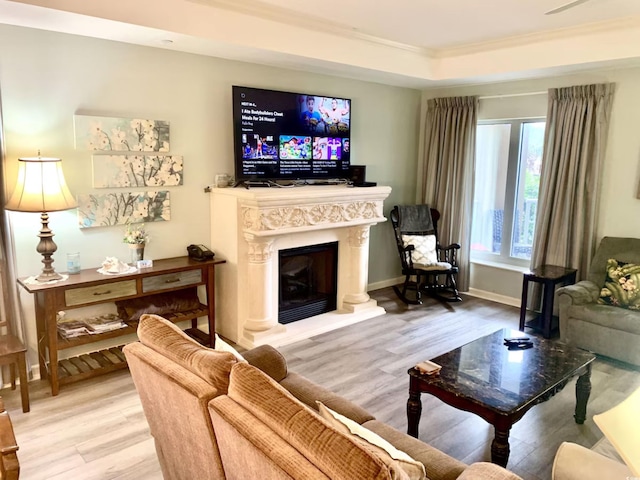 living room featuring hardwood / wood-style flooring, a tray ceiling, and crown molding