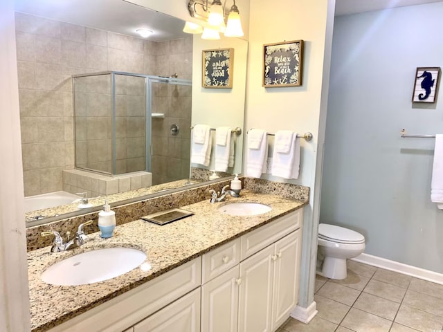 bathroom with tile patterned flooring, vanity, toilet, and a shower with shower door