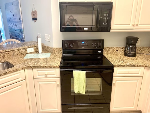 kitchen with light stone countertops, sink, white cabinets, and black appliances