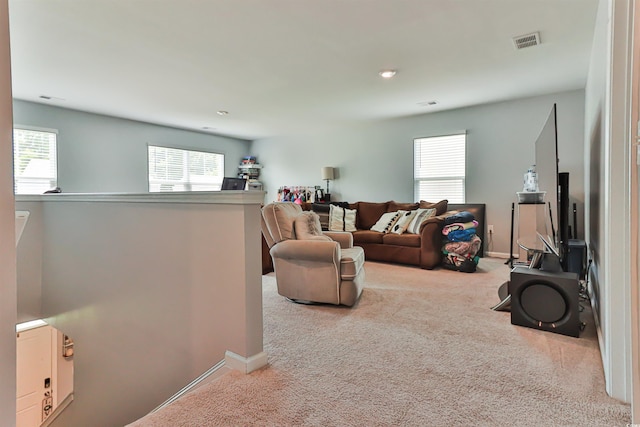 living room featuring a wealth of natural light and light colored carpet