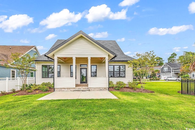 back of property with a lawn and covered porch