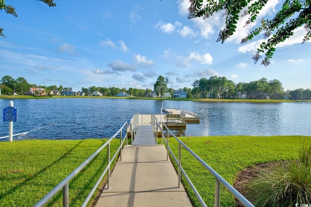 view of dock with a lawn and a water view