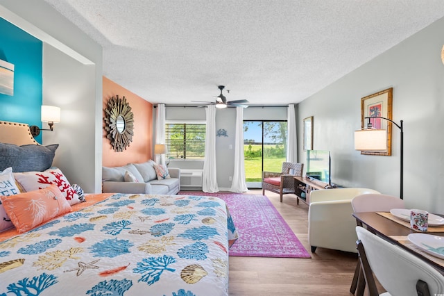 bedroom featuring a textured ceiling, light hardwood / wood-style floors, and ceiling fan