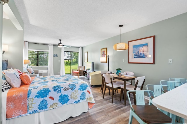 bedroom with hardwood / wood-style floors and a textured ceiling