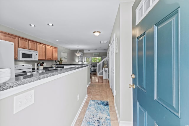 kitchen with white appliances, decorative light fixtures, sink, and light tile patterned floors