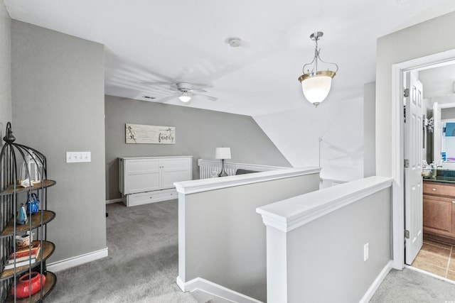 hallway featuring light colored carpet and vaulted ceiling