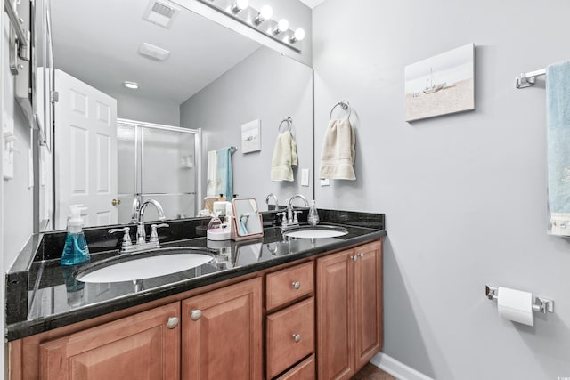 bathroom with vanity and a shower with door