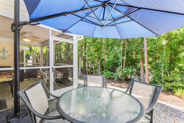 view of patio featuring ceiling fan and a sunroom