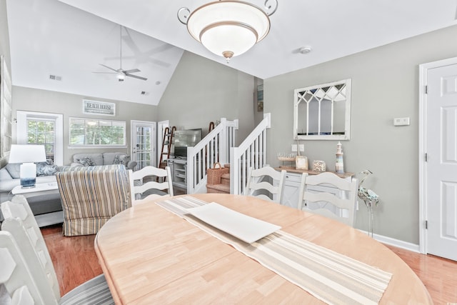 dining space featuring ceiling fan, high vaulted ceiling, and light hardwood / wood-style floors