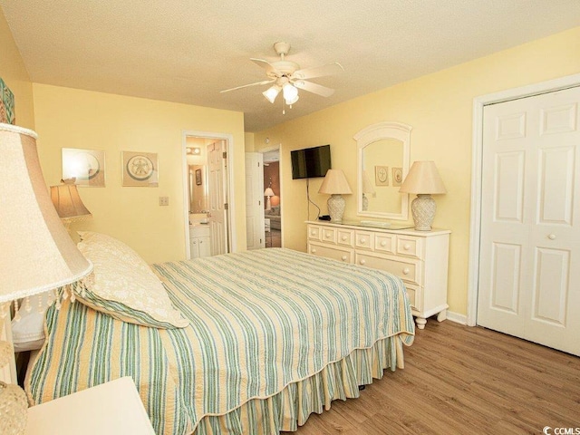 bedroom with hardwood / wood-style floors, ceiling fan, a closet, and ensuite bath