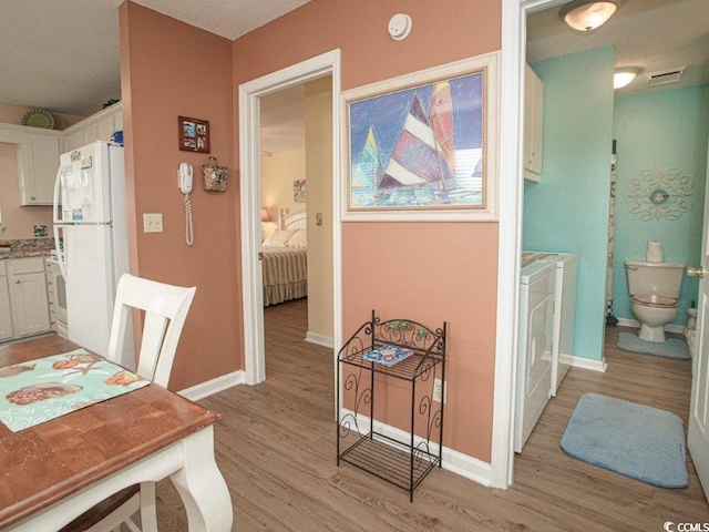 dining area with washer and clothes dryer and light hardwood / wood-style floors