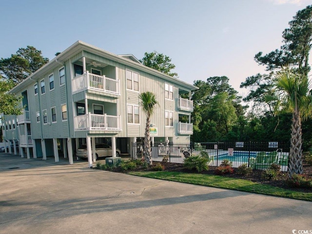 view of building exterior with cooling unit and a community pool