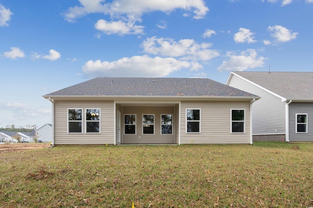 rear view of property featuring a lawn