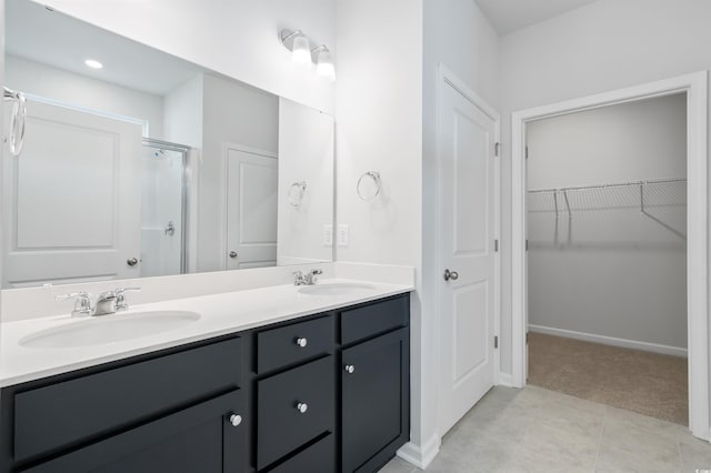 bathroom with tile patterned flooring, vanity, and a shower with door