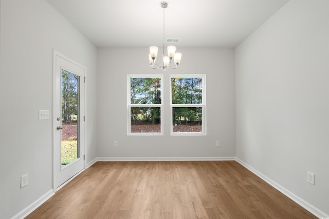 empty room featuring light hardwood / wood-style flooring and an inviting chandelier