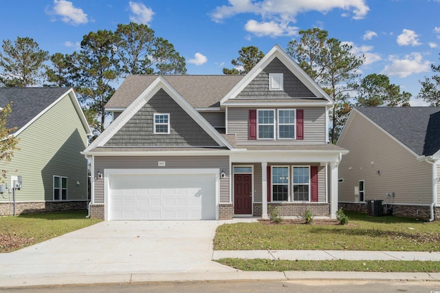 craftsman house with central air condition unit, a front yard, and a garage