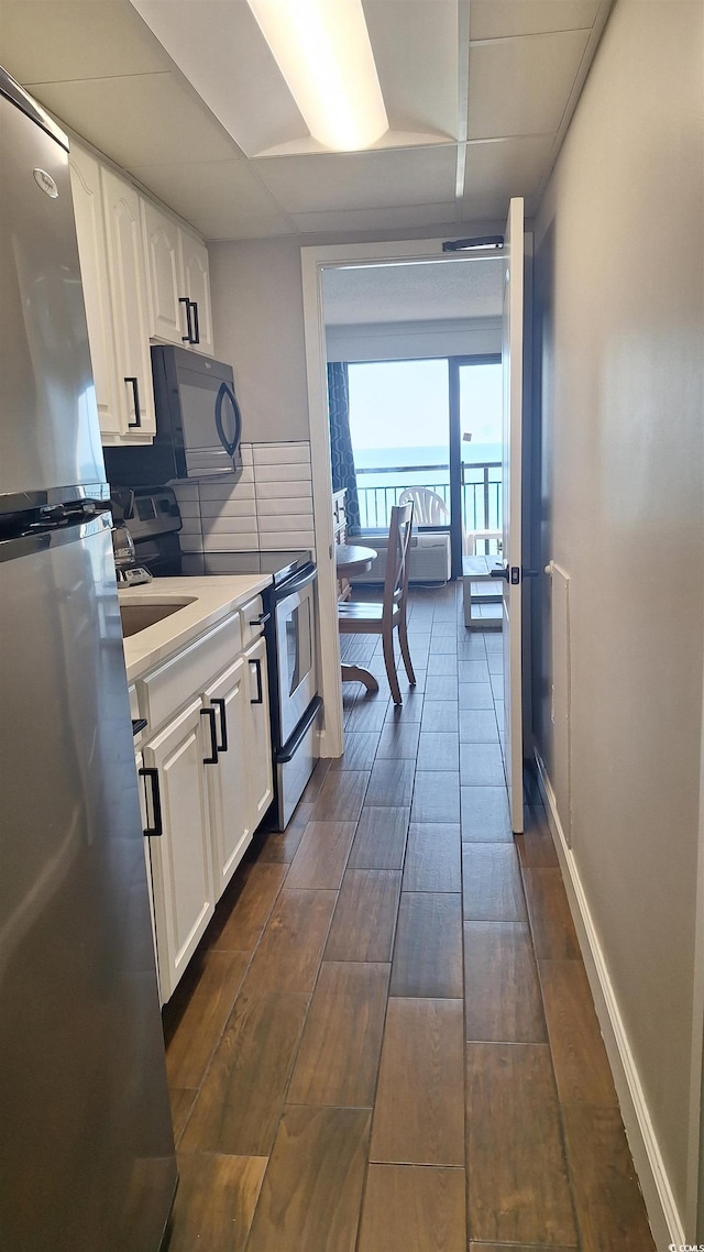 kitchen featuring white cabinetry, stainless steel fridge, dark wood-type flooring, and range with electric cooktop