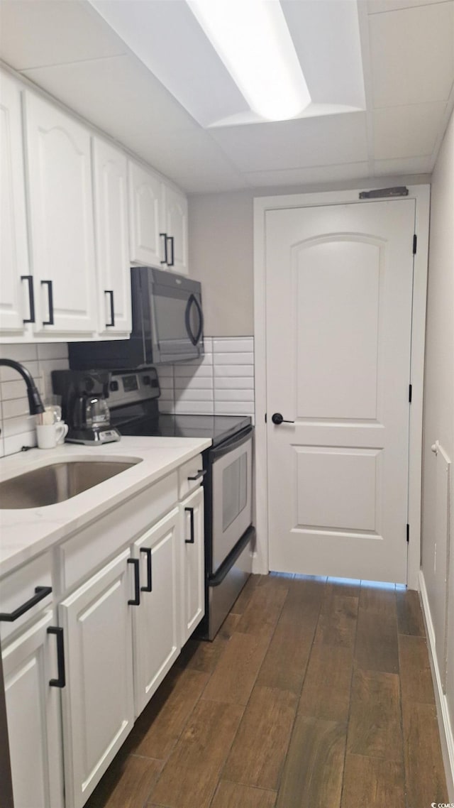 kitchen featuring stainless steel range with electric stovetop, backsplash, sink, dark hardwood / wood-style flooring, and white cabinetry