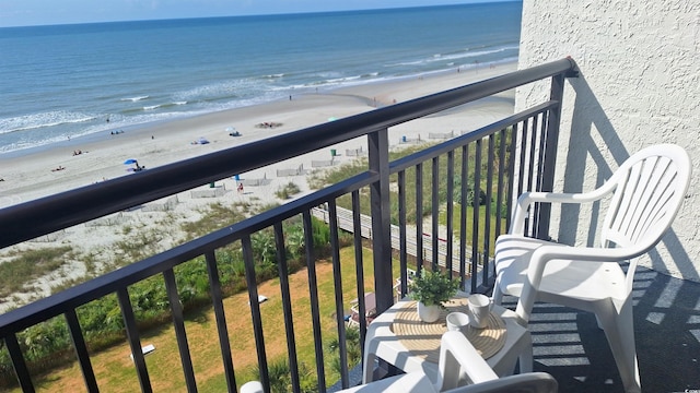 balcony featuring a water view and a view of the beach