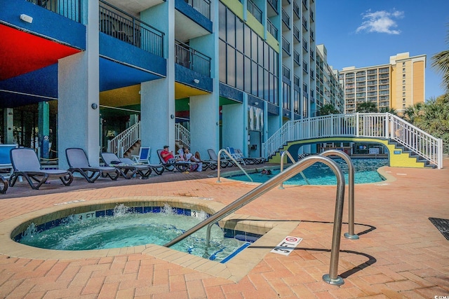 view of pool with a hot tub