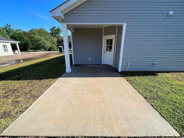 property entrance featuring a yard and a carport