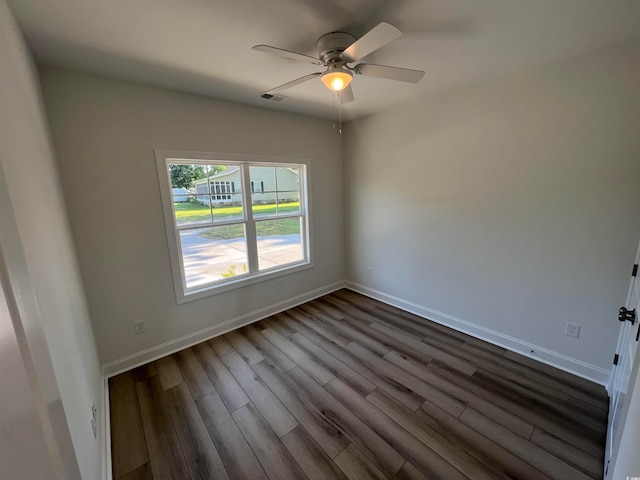 empty room featuring dark wood-type flooring and ceiling fan