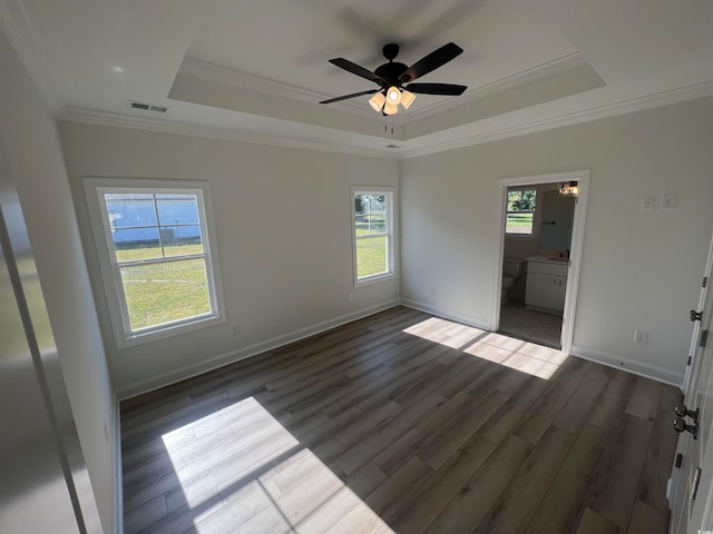 unfurnished room with dark hardwood / wood-style flooring, ornamental molding, and a raised ceiling