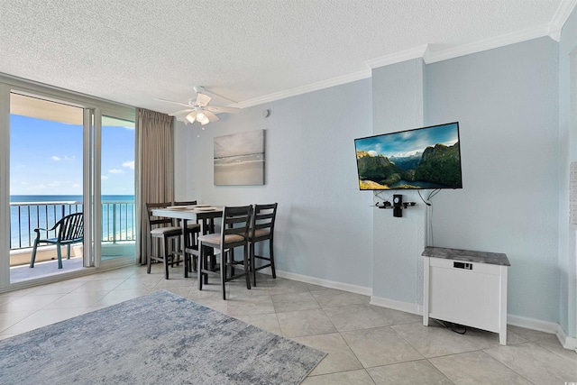 dining area with a water view, ceiling fan, ornamental molding, and baseboards