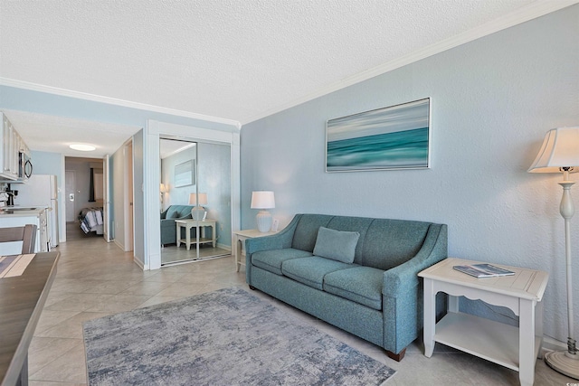 living area with a textured ceiling, ornamental molding, light tile patterned floors, and baseboards