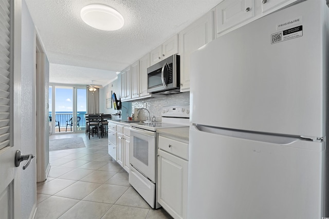 kitchen featuring light countertops, white appliances, white cabinetry, and decorative backsplash