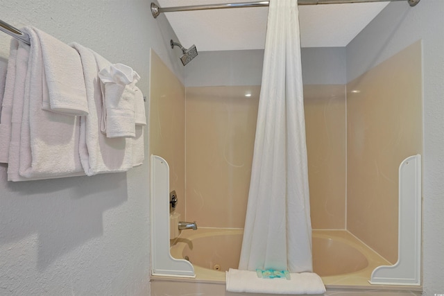 full bathroom featuring shower / tub combo with curtain and a textured wall