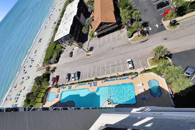 birds eye view of property featuring a water view and a beach view