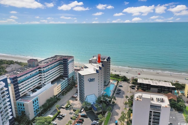 drone / aerial view featuring a city view, a water view, and a beach view