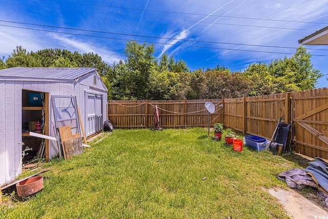 view of yard featuring an outbuilding, a storage shed, and a fenced backyard