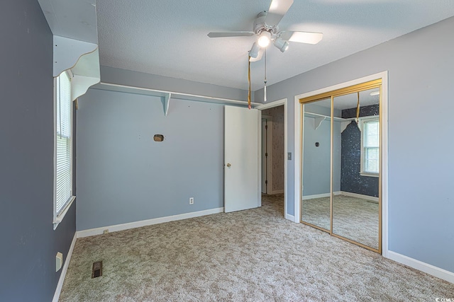 unfurnished bedroom with visible vents, baseboards, ceiling fan, carpet, and a textured ceiling