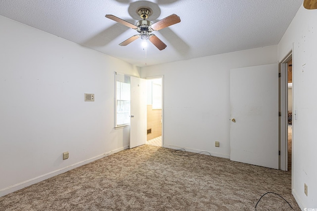 unfurnished bedroom with baseboards, a textured ceiling, ensuite bath, and carpet flooring