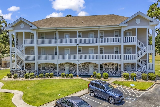 view of property featuring uncovered parking and stairs