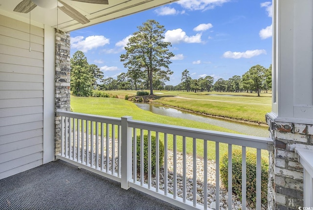 balcony featuring a ceiling fan and a water view