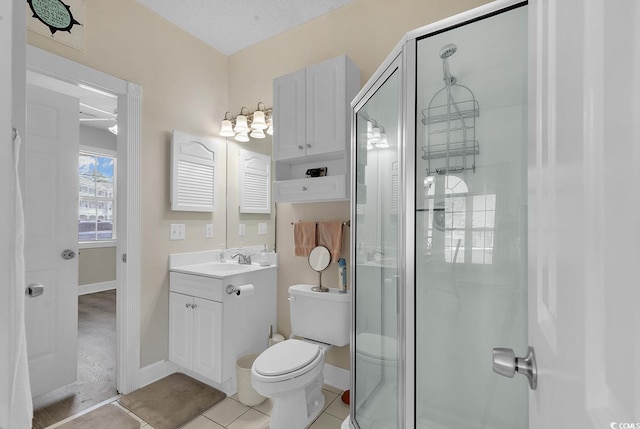 bathroom with a shower stall, vanity, toilet, and tile patterned floors