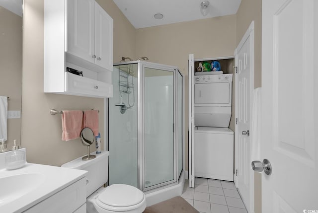 full bath featuring stacked washer and clothes dryer, toilet, vanity, a shower stall, and tile patterned floors