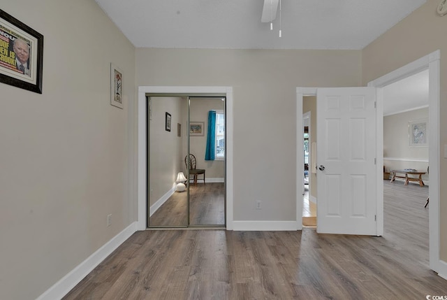 unfurnished bedroom featuring a closet, light wood-style flooring, and baseboards