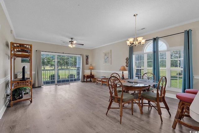 dining room with a healthy amount of sunlight, crown molding, and wood finished floors