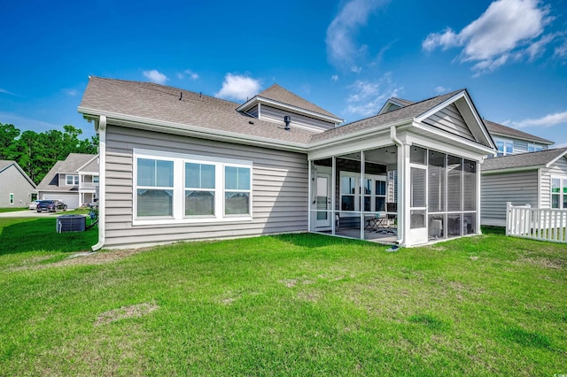 back of house featuring central AC, a sunroom, and a lawn