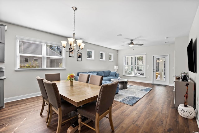 dining space with dark wood-type flooring and ceiling fan with notable chandelier