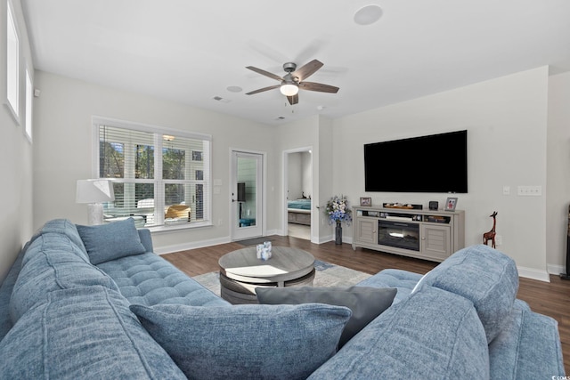 living room featuring dark wood-type flooring and ceiling fan