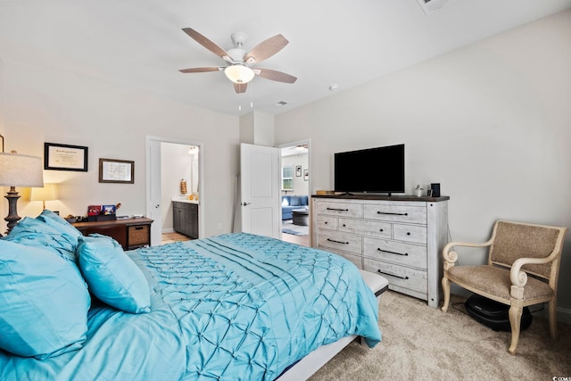 bedroom with light carpet, ensuite bathroom, and ceiling fan