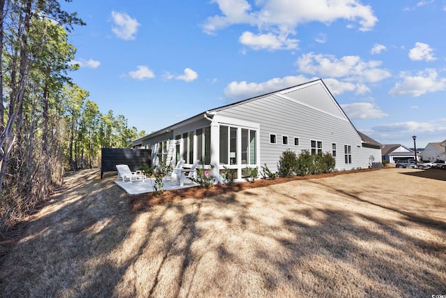 view of property exterior with a patio and a sunroom