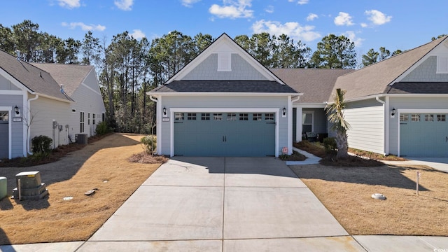 view of front of home with central air condition unit and a garage